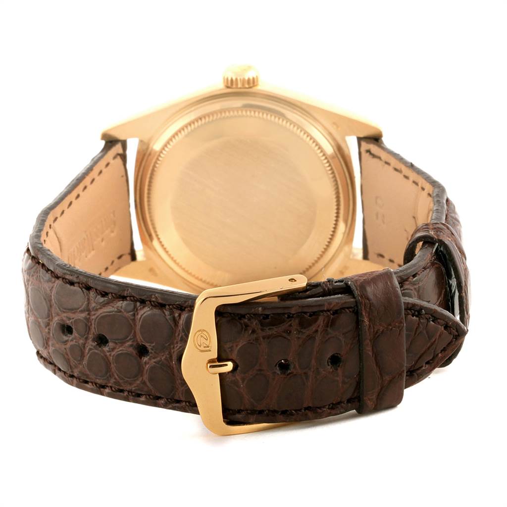 The image shows the back view of a Rolex President 18038 Men
s Yellow Gold Brown Dial 18038 Men
s Yellow Gold Brown Dial watch with a brown leather strap and gold buckle.