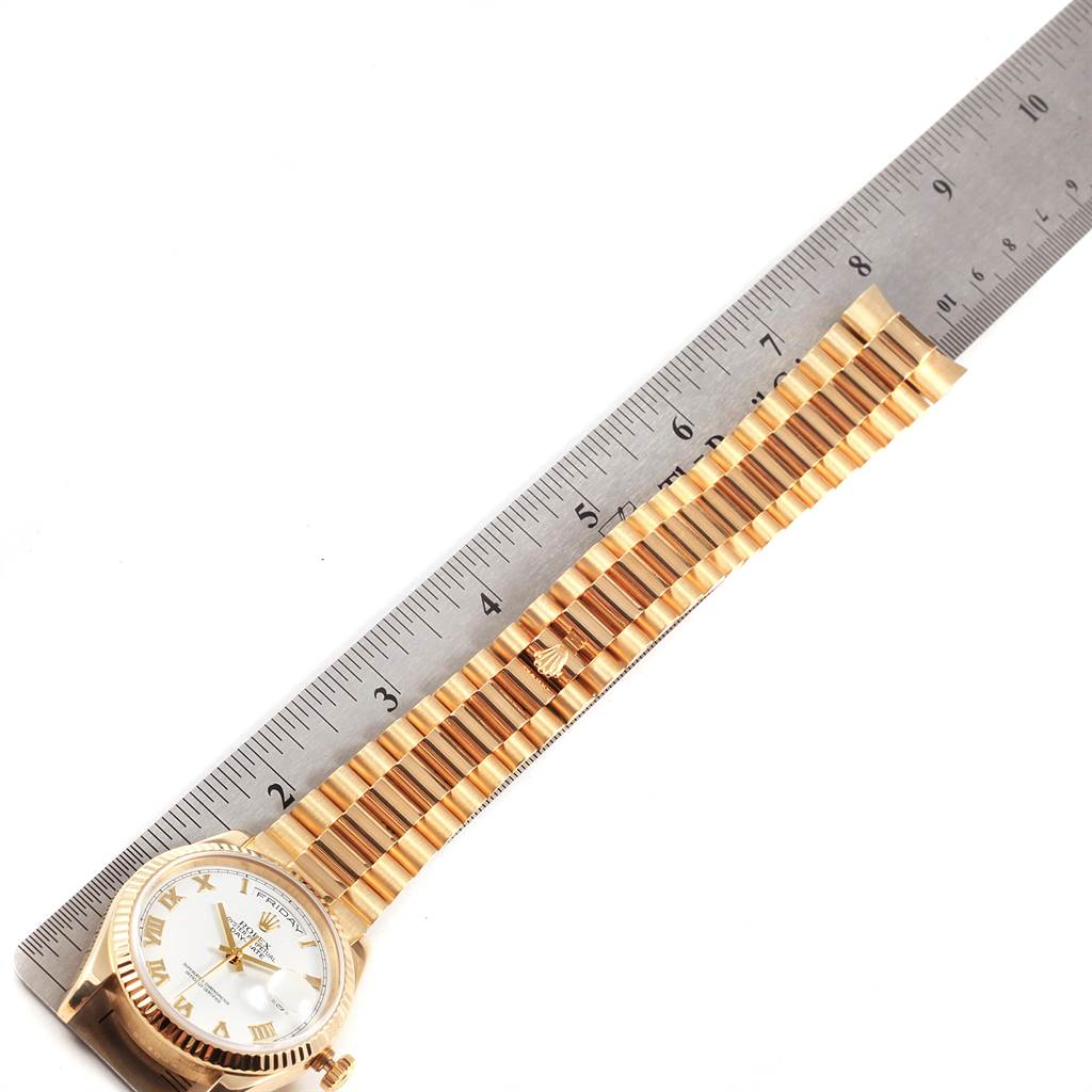 The image shows a Rolex President 118238 Men
s Yellow Gold White Dial 118238 Men
s Yellow Gold White Dial model watch with the full bracelet and part of the dial, measured against a ruler.
