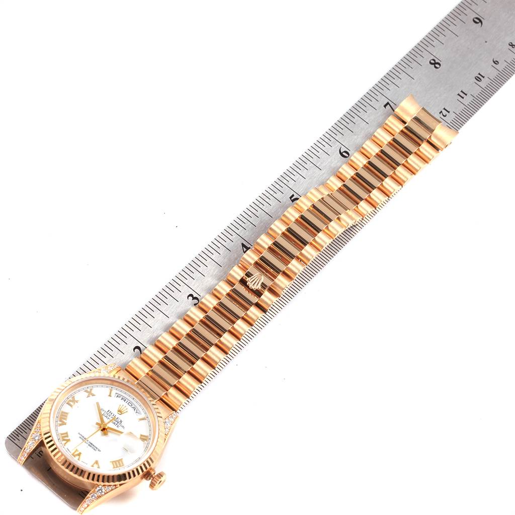The image shows a Rolex President 118338 Men
s Yellow Gold White Dial 118338 Men
s Yellow Gold White Dial model watch laying flat with its full band measured against a ruler.