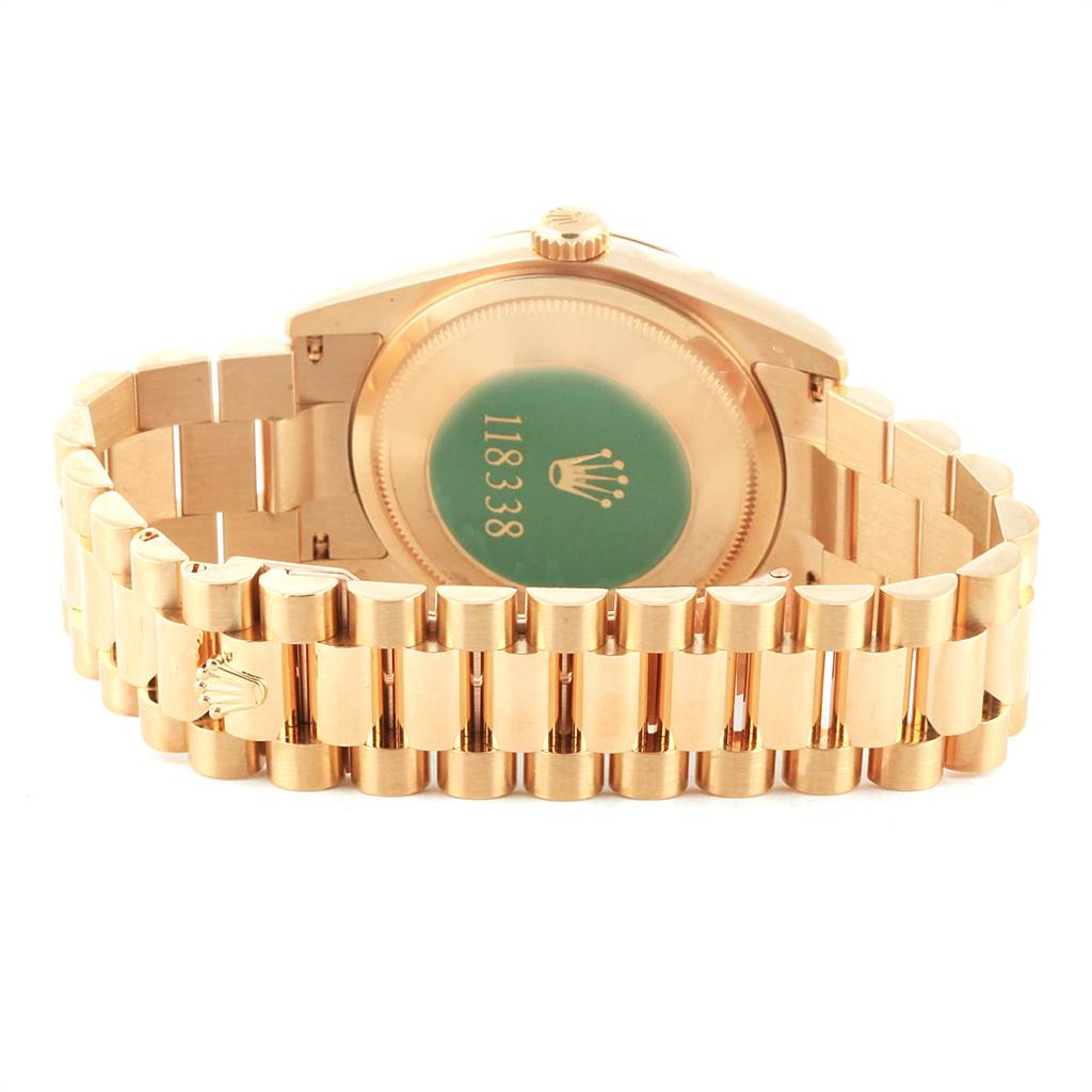 The image shows the back case and bracelet of a Rolex President 118338 Men
s Yellow Gold White Dial 118338 Men
s Yellow Gold White Dial model watch, highlighting the case back engraving and clasp.