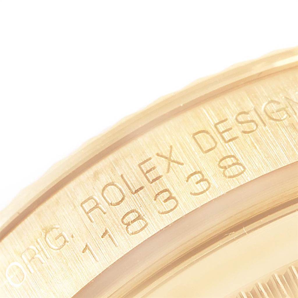 This image shows a close-up of the engraved bezel of a Rolex President 118338 Men
s Yellow Gold White Dial 118338 Men
s Yellow Gold White Dial model watch.