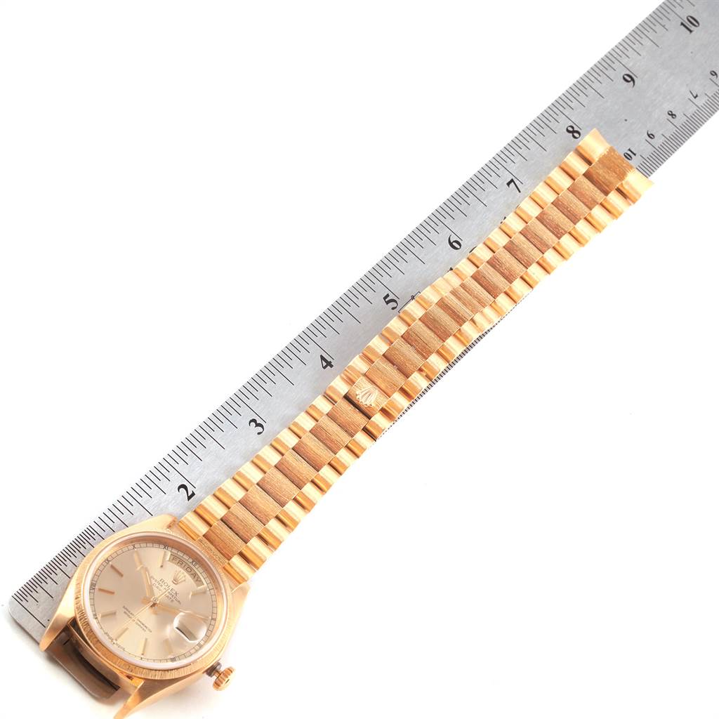 The image shows a Rolex President 18078 Men
s Yellow Gold Champagne Dial 18078 Men
s Yellow Gold Champagne Dial model watch laid flat next to a ruler, highlighting the watch case and bracelet.