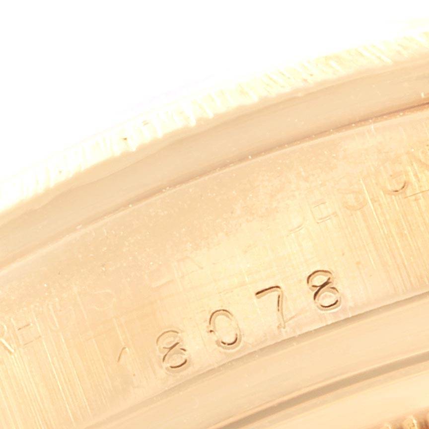 The image shows a close-up of the case back edge of a Rolex President 18078 Men
s Yellow Gold Champagne Dial 18078 Men
s Yellow Gold Champagne Dial model watch, revealing the engraved serial number.