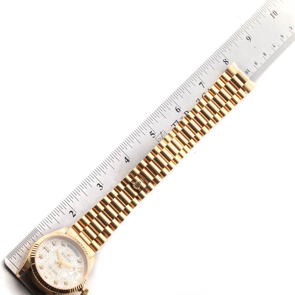 The image shows a Rolex President 118238 Men
s Yellow Gold Silver Dial 118238 Men
s Yellow Gold Silver Dial model watch laid out flat next to a ruler, displaying its case, dial, and bracelet.