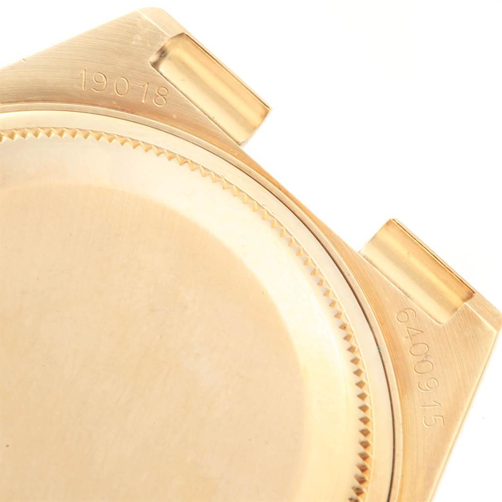 This image shows the back case and serial numbers of a Rolex President 19018 Men
s Yellow Gold Black Dial 19018 Men
s Yellow Gold Black Dial model watch from an angled top-down view.