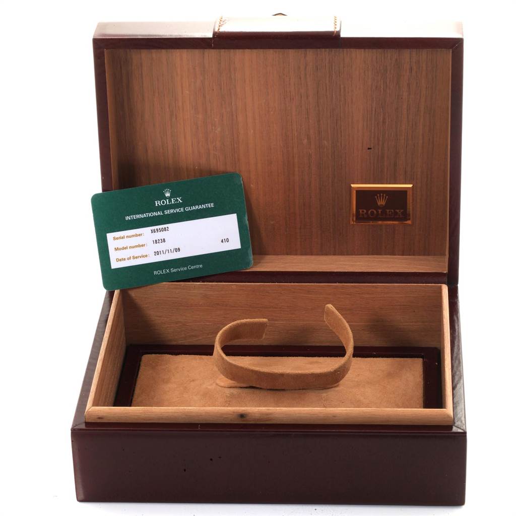 The image shows a Rolex President 18238 Men
s Yellow Gold Champagne Dial 18238 Men
s Yellow Gold Champagne Dial model watch box and an international service guarantee card inside an open wooden case.