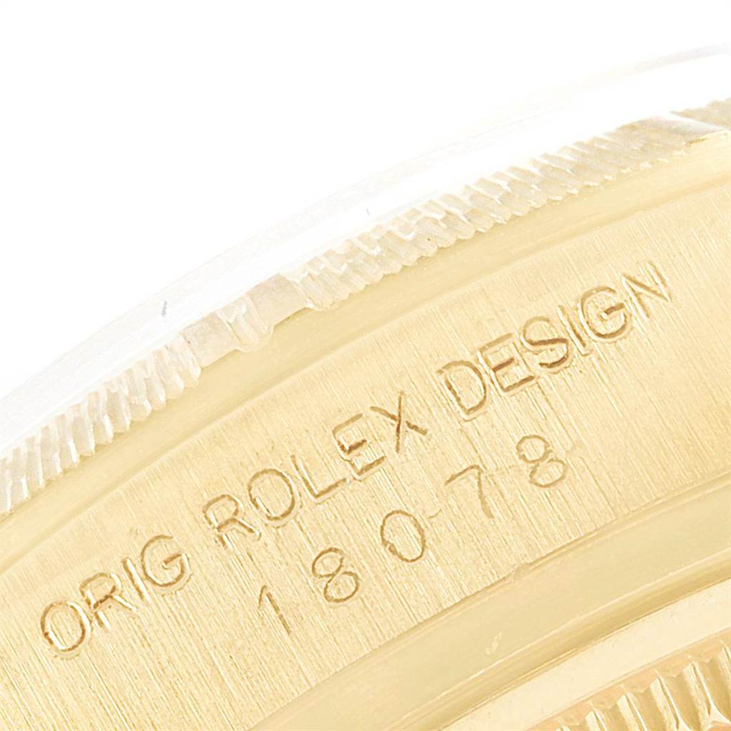 The image shows an engraved portion of a Rolex President 18078 Men
s Yellow Gold Brown Dial 18078 Men
s Yellow Gold Brown Dial model watch, displaying the text "ORIG ROLEX DESIGN 18078."