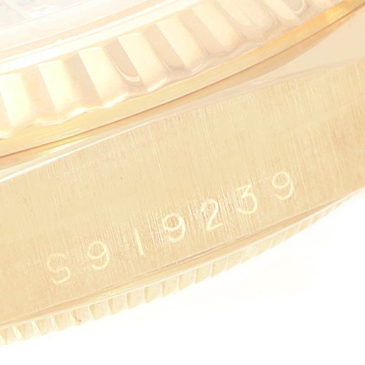 This image shows a close-up of a Rolex President 18238 Men
s Yellow Gold Champagne Dial 18238 Men
s Yellow Gold Champagne Dial model, focusing on the fluted bezel and part of the watch case with engraved numbers.
