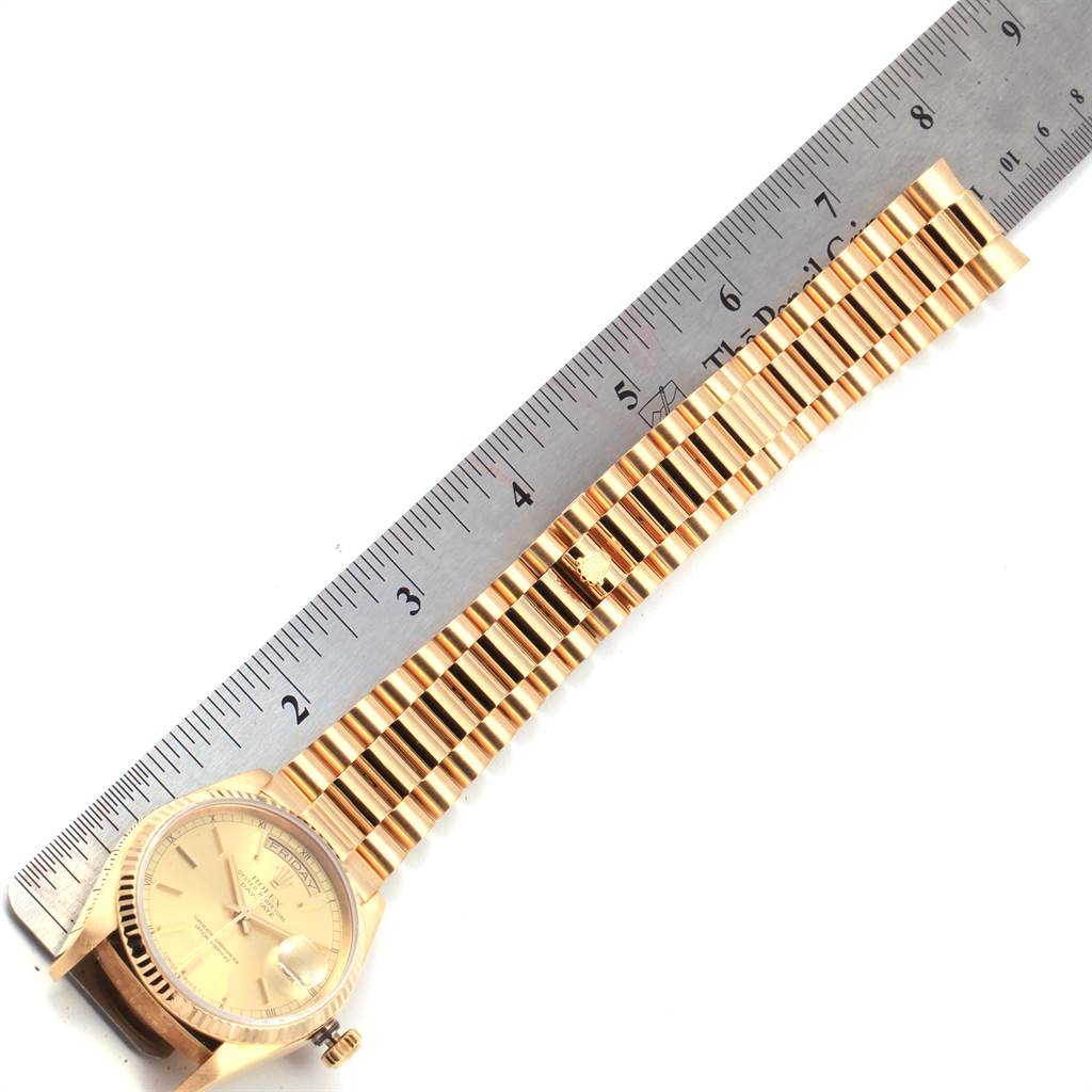 The image shows the Rolex President 18038 Men
s Yellow Gold Champagne Dial 18038 Men
s Yellow Gold Champagne Dial model watch laid flat with its face, band, and clasp visible alongside a ruler for scale.