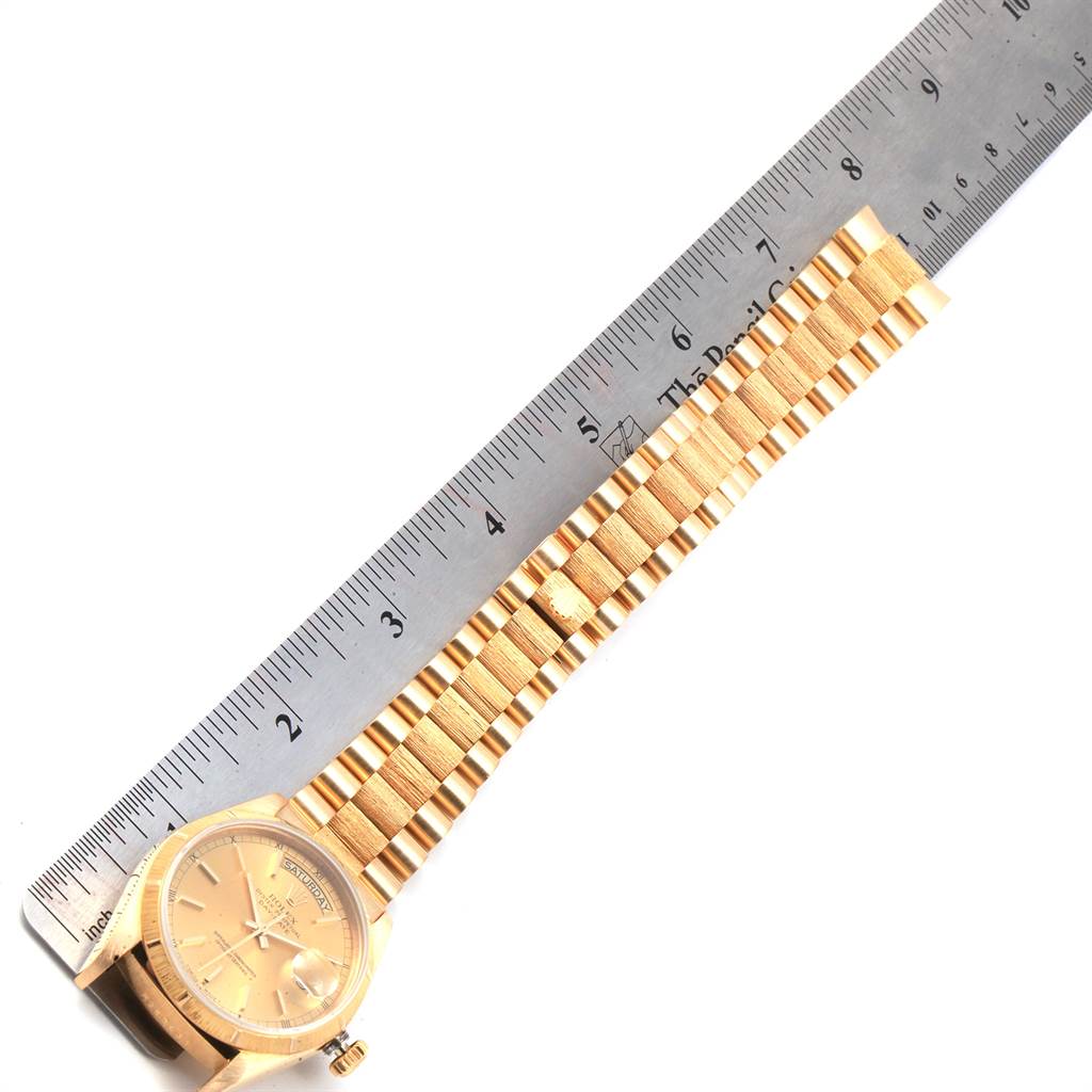 The image shows a Rolex President 18078 Men
s Yellow Gold Champagne Dial 18078 Men
s Yellow Gold Champagne Dial model watch laid next to a ruler, displaying the face and bracelet.