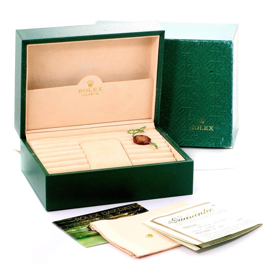 The image shows an open green Rolex President 18238 Men
s Yellow Gold Champagne Dial 18238 Men
s Yellow Gold Champagne Dial watch box with accompanying paperwork, a tag, and a polishing cloth.