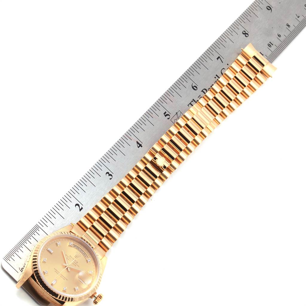 The image shows a Rolex President 18238 Men
s Yellow Gold Champagne Dial 18238 Men
s Yellow Gold Champagne Dial model watch laid flat with its bracelet and part of the dial visible, next to a ruler for scale.