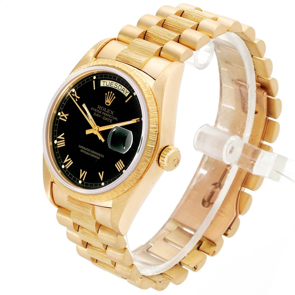 This is a Rolex President 18038 Men
s Yellow Gold Black Dial 18038 Men
s Yellow Gold Black Dial model watch shown at an angle showcasing the face, bezel, crown, and part of the bracelet.