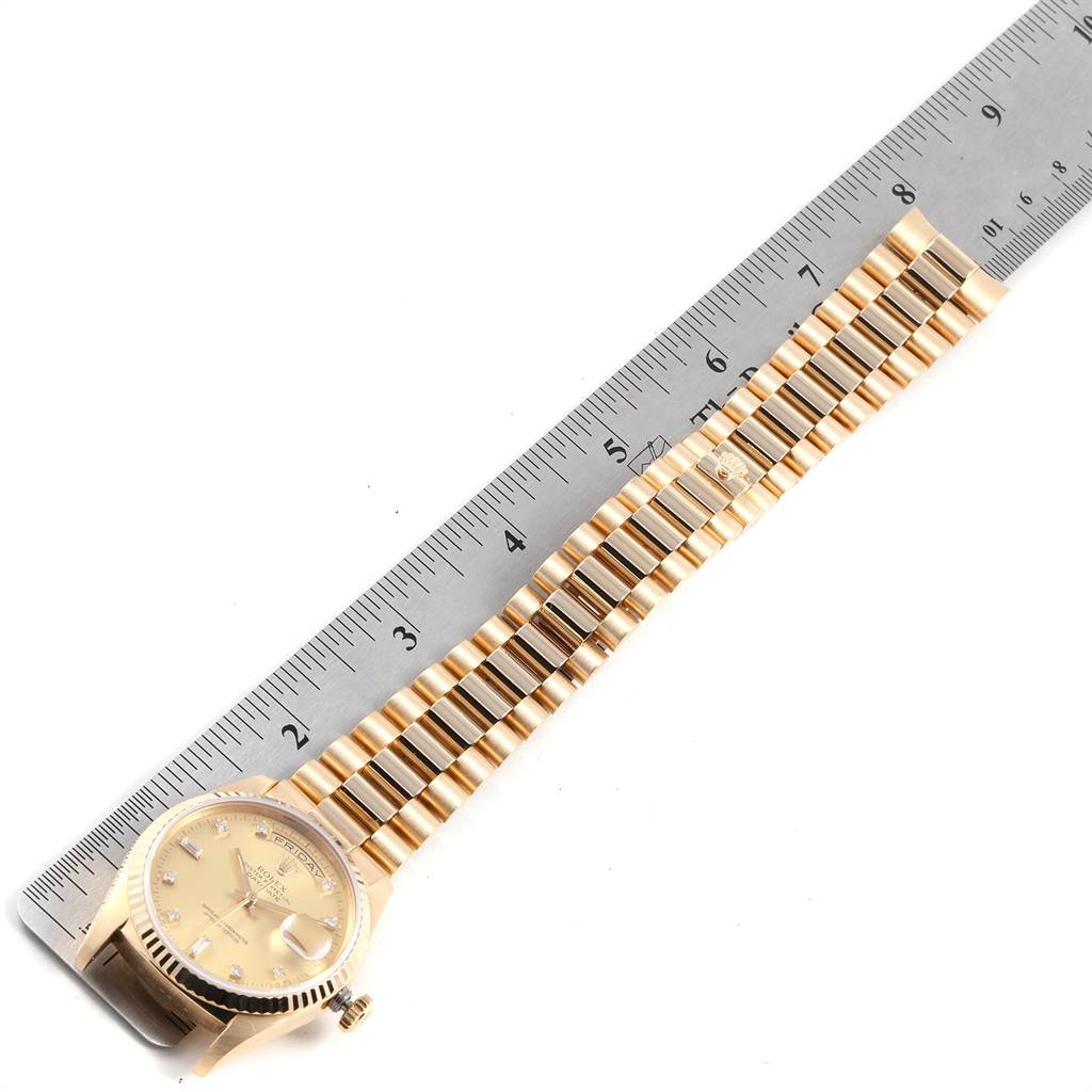 The image shows a Rolex President 18238 Men
s Yellow Gold Champagne Dial 18238 Men
s Yellow Gold Champagne Dial model watch placed next to a ruler, highlighting the watch face and bracelet.
