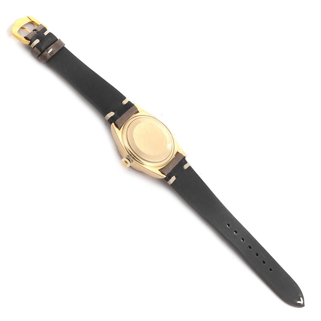 The image shows the back view of a Rolex President 18078 Men
s Yellow Gold Blue Dial 18078 Men
s Yellow Gold Blue Dial model watch with a black leather strap and gold buckle.