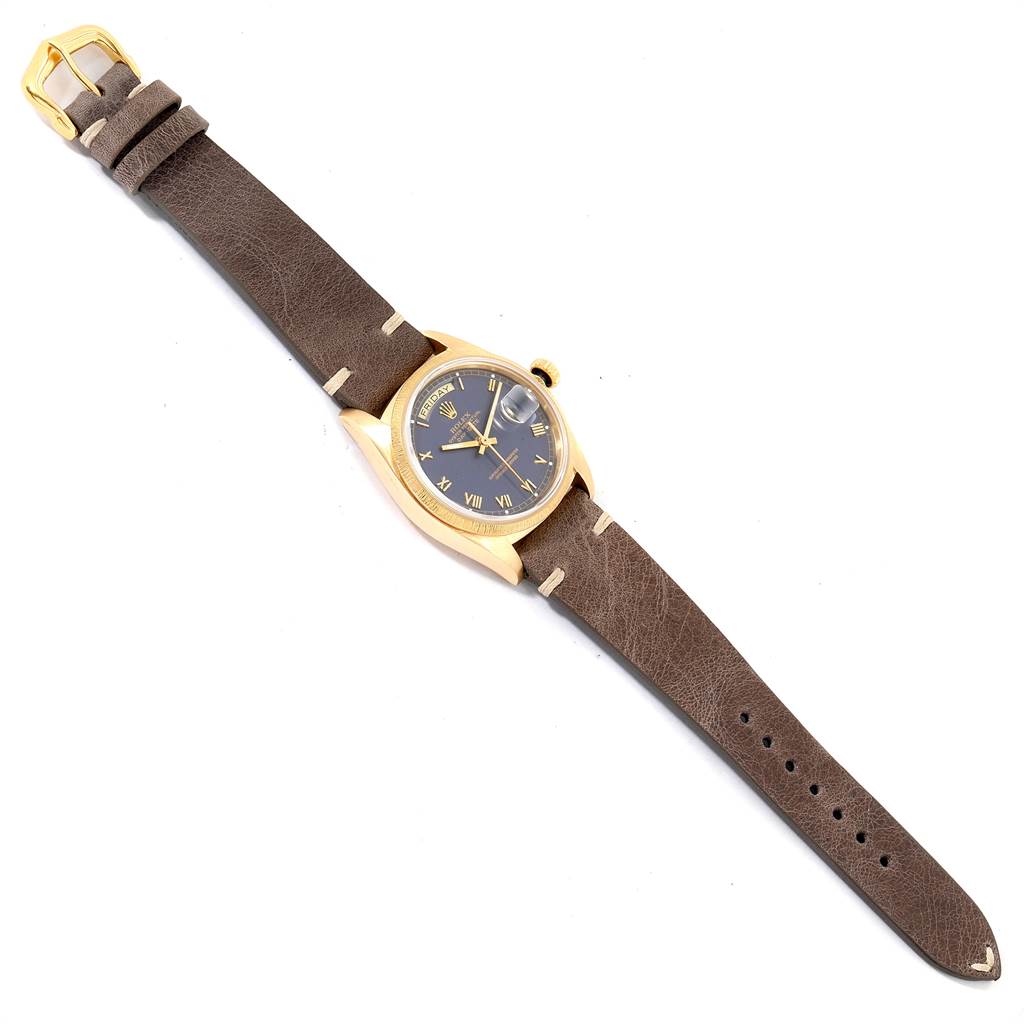 The image shows a Rolex President 18078 Men
s Yellow Gold Blue Dial 18078 Men
s Yellow Gold Blue Dial model watch with a brown leather strap, gold case, and black dial, viewed from above.