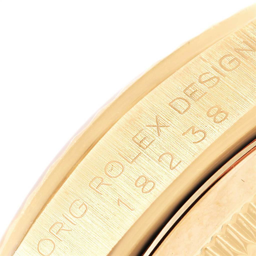 This close-up image shows the engraved side of a Rolex President 18238 Men
s Yellow Gold Champagne Dial 18238 Men
s Yellow Gold Champagne Dial model watch with "ORIG ROLEX DESIGN" text.