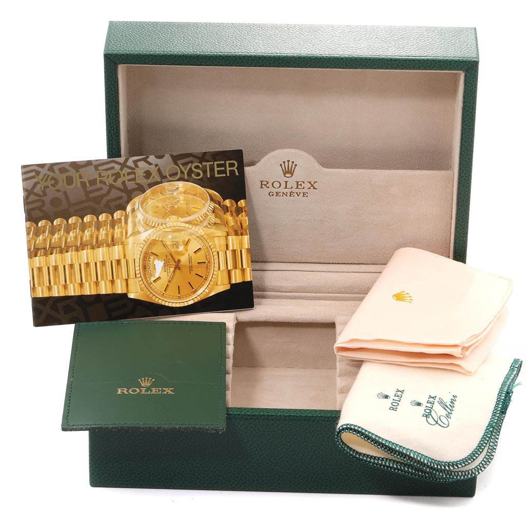 The image shows the Rolex President 18238 Men
s Yellow Gold Champagne Dial 18238 Men
s Yellow Gold Champagne Dial model watch box with related accessories like a booklet, cloth, and card, viewed from the front.