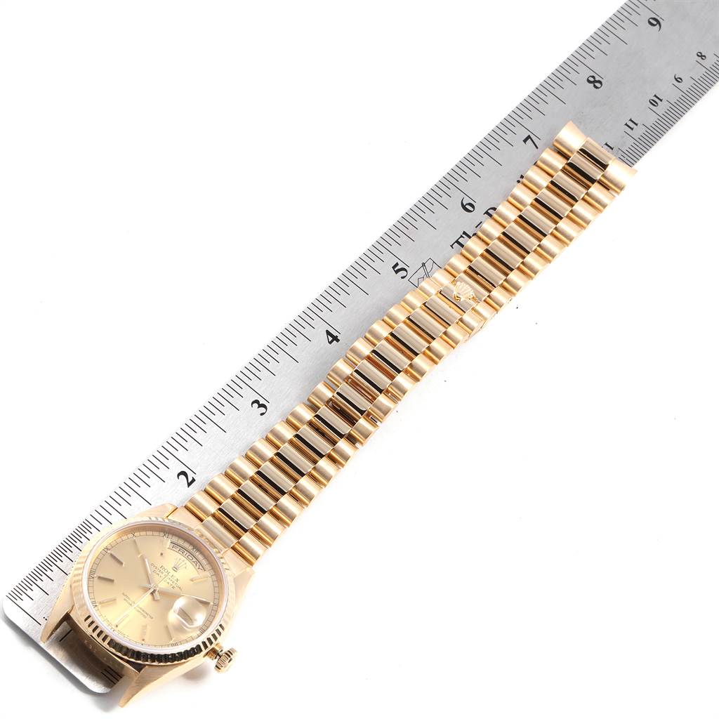 This image shows a Rolex President 18238 Men's Yellow Gold Champagne Dial 18238 Men's Yellow Gold Champagne Dial model watch laid flat next to a ruler, displaying the face and entire bracelet.
