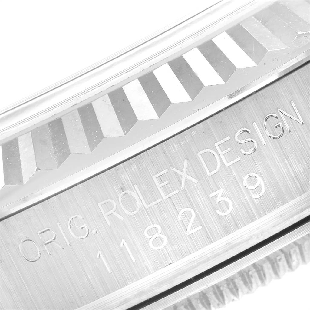 The image shows a close-up angle of the side engraving and part of the fluted bezel of a Rolex President 118239 Men's White Gold Brown Dial 118239 Men's White Gold Brown Dial model watch.