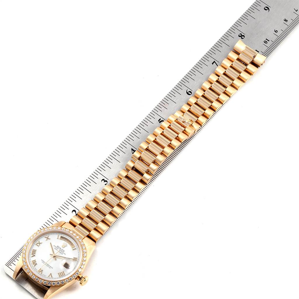 The image shows the Rolex President 18238 Men
s Yellow Gold Mother of Pearl Dial 18238 Men
s Yellow Gold Mother of Pearl Dial watch laid flat with a ruler, displaying its bracelet and dial from a top-down angle.