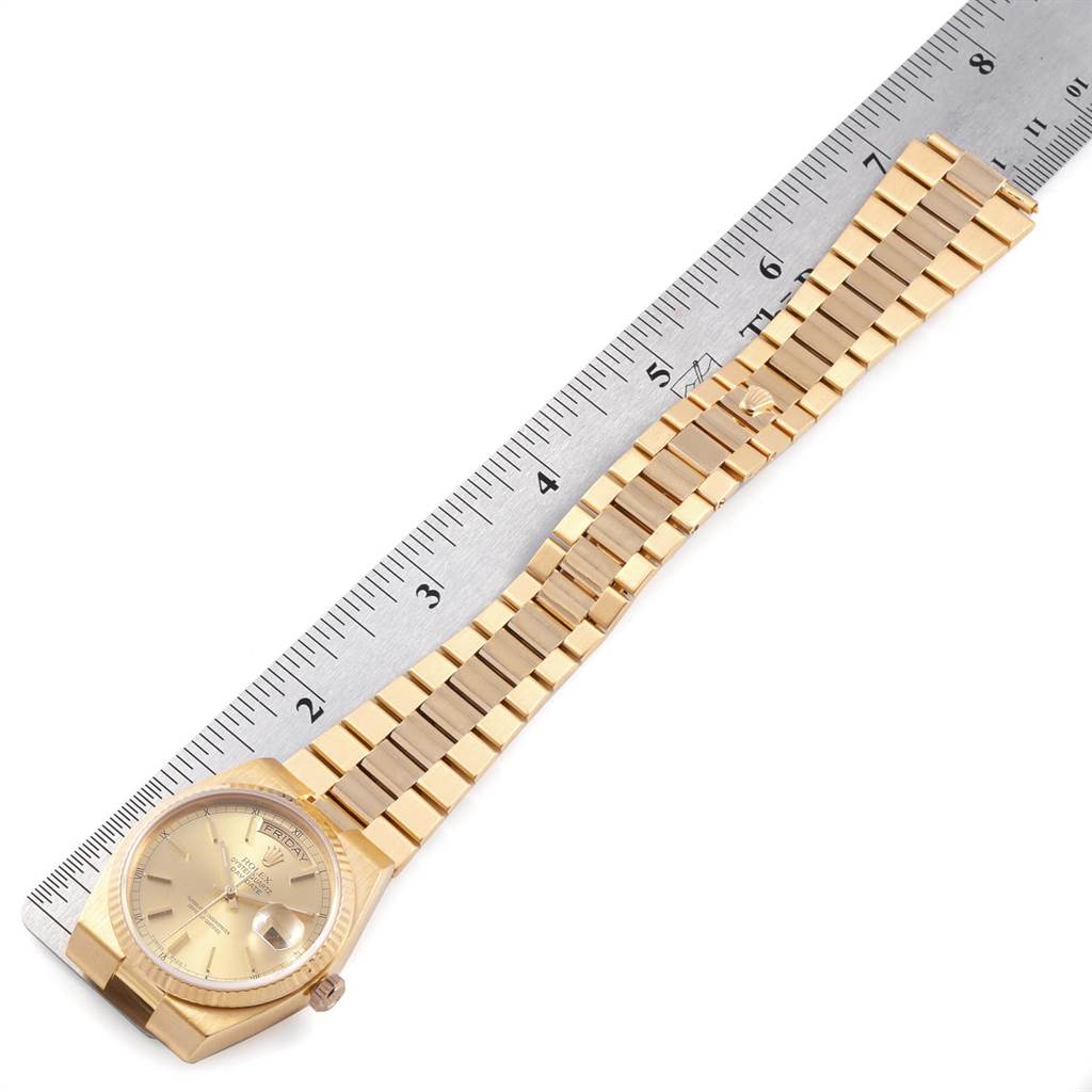 The image shows the front view of a Rolex President 19018 Men
s Yellow Gold Champagne Dial 19018 Men
s Yellow Gold Champagne Dial model watch, including the dial and bracelet, with a ruler for scale.