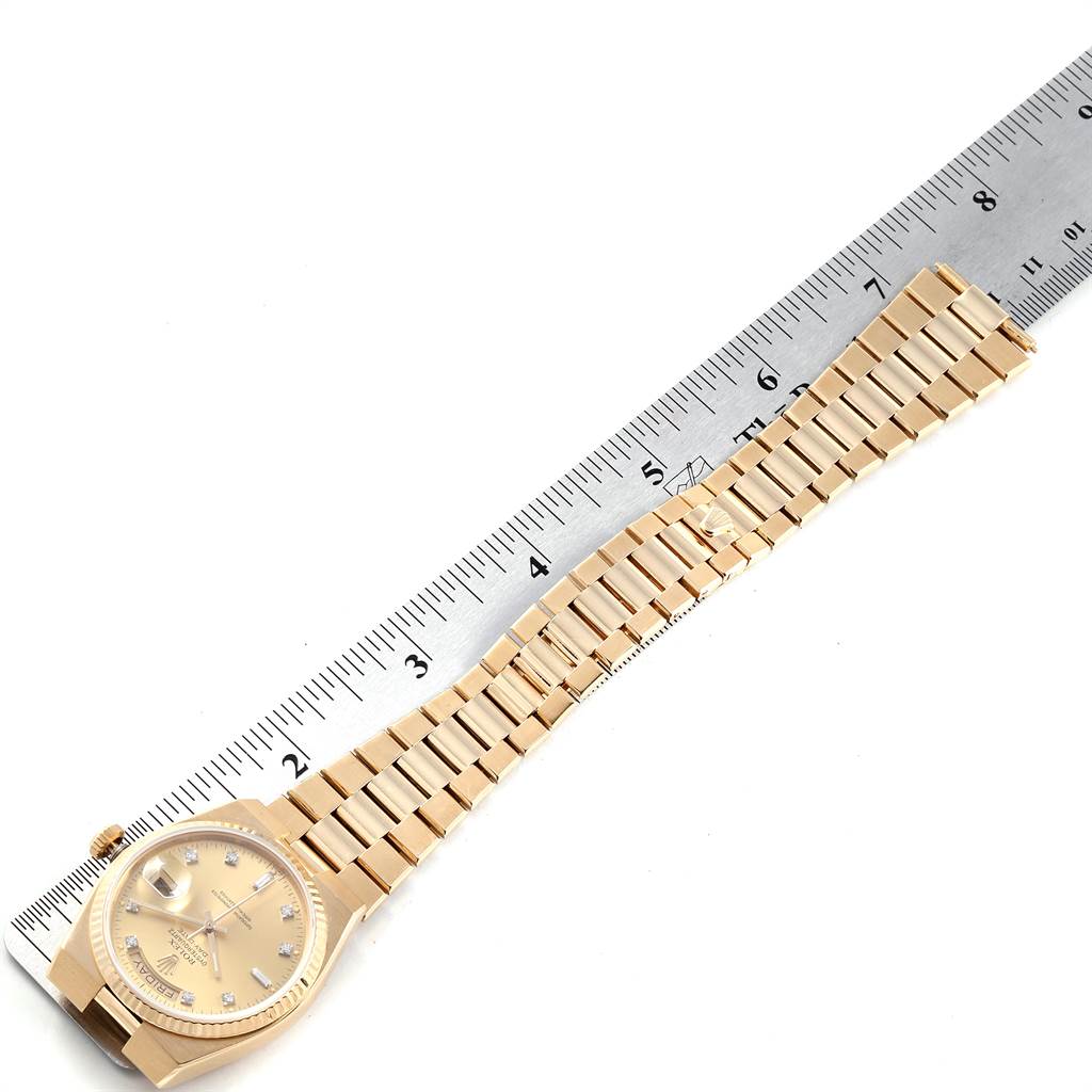 This image shows a side angle of the Rolex President 16240 Men
s Yellow Gold Champagne Dial 16240 Men
s Yellow Gold Champagne Dial watch, including the watch face, bezel, and bracelet, next to a measuring ruler.