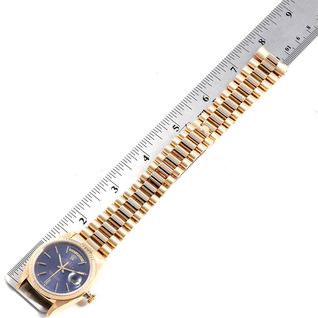 This image shows a Rolex President 18038 Men's Yellow Gold Blue Dial 18038 Men's Yellow Gold Blue Dial model watch laid flat next to a measuring ruler, focusing on the bracelet and watch face.