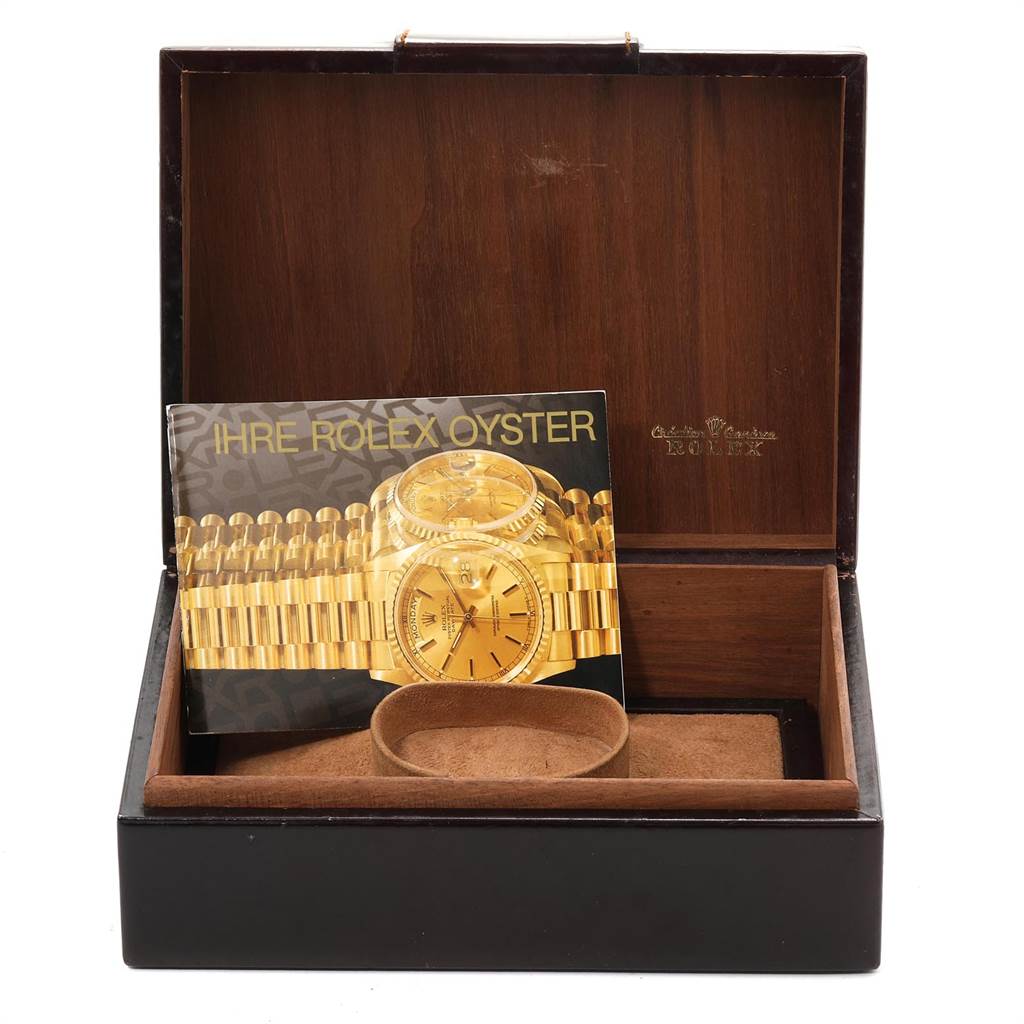 The image shows a Rolex President 14418 Men
s Yellow Gold Brown Dial 14418 Men
s Yellow Gold Brown Dial model watch box with its booklet and a watch holder inside.