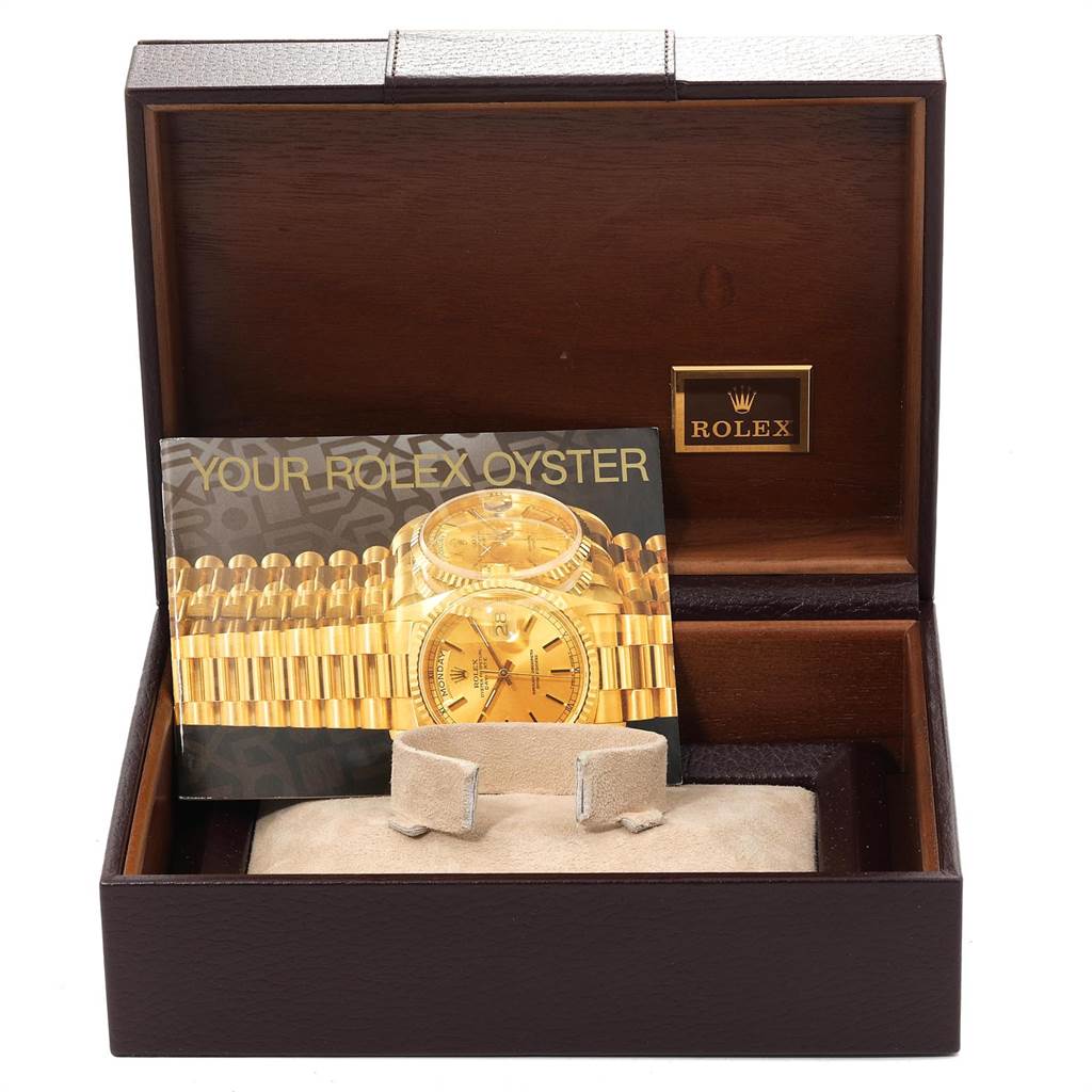 The image shows an open Rolex President 18078 Men
s Yellow Gold Black Dial 18078 Men
s Yellow Gold Black Dial watch box with a booklet and cushion inside.