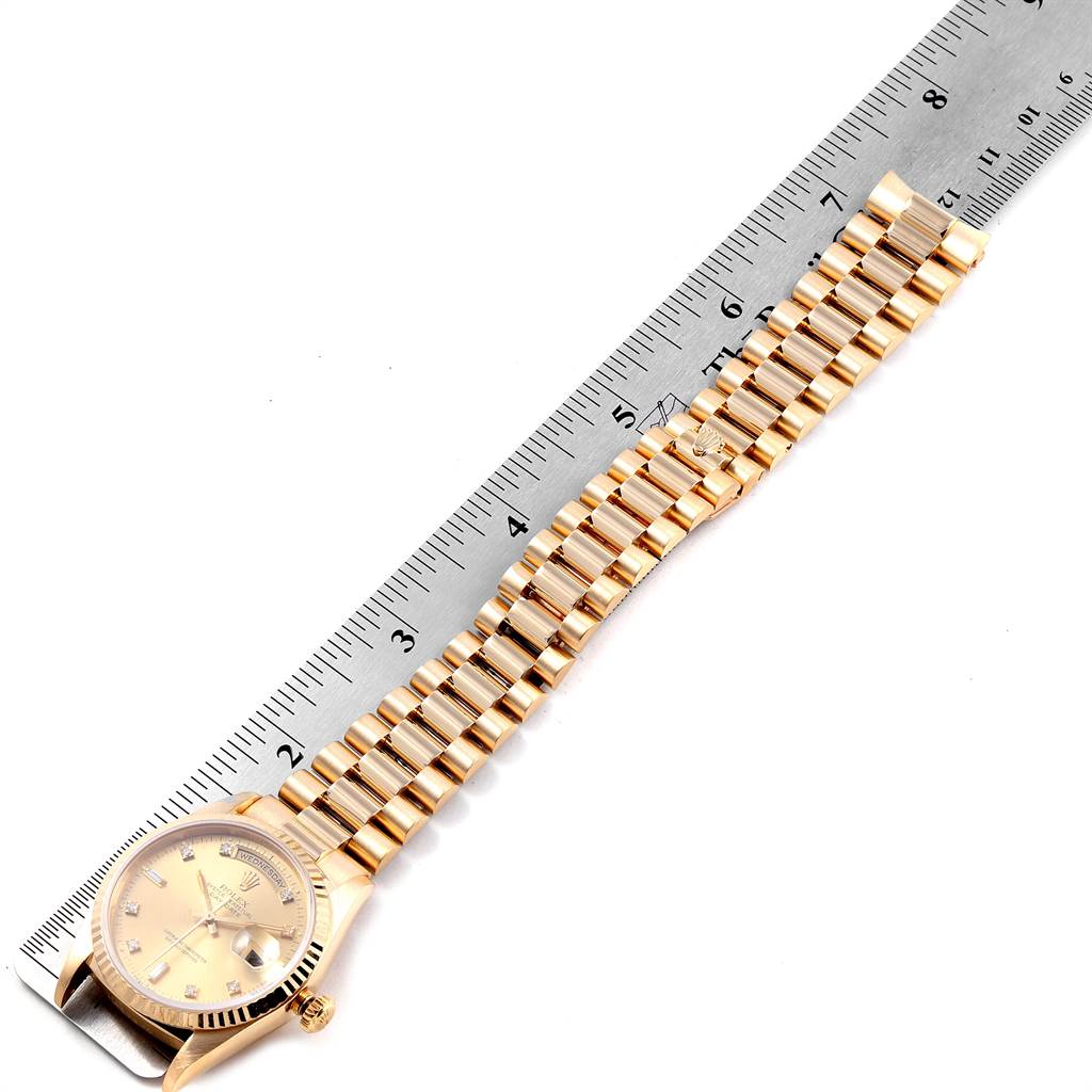 The image shows a top view of a Rolex President 18238 Men
s Yellow Gold Champagne Dial 18238 Men
s Yellow Gold Champagne Dial model watch with its linked bracelet measured against a ruler.