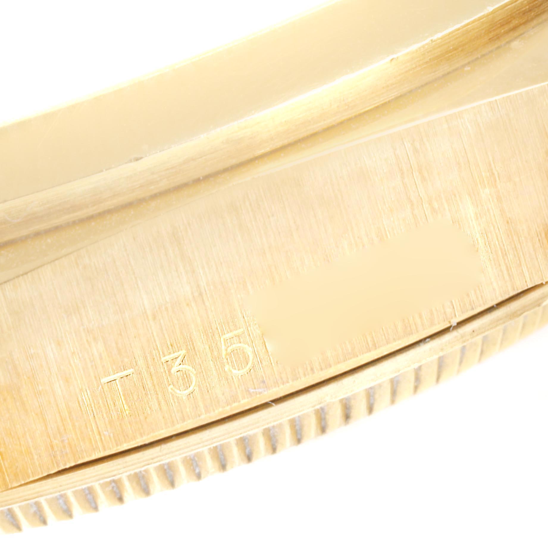 The image shows a close-up of the side of a Rolex President 18208 Men's Yellow Gold Blue Dial 18208 Men's Yellow Gold Blue Dial model watch, highlighting part of the case and the engraving.