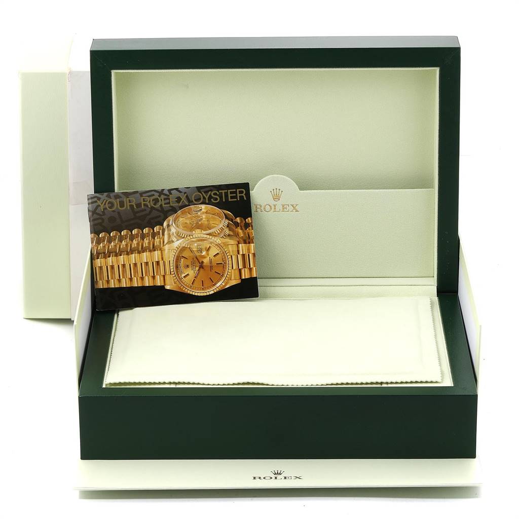 The image shows an empty Rolex watch box for the President model with a booklet and cloth inside.