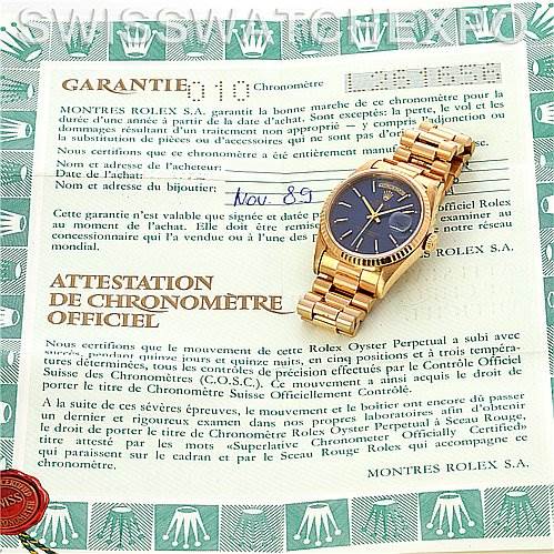 The Rolex President 18238 Men's Yellow Gold Blue Dial 18238 Men's Yellow Gold Blue Dial watch is shown from a top-down angle, placed on its warranty and chronometer certification documents.