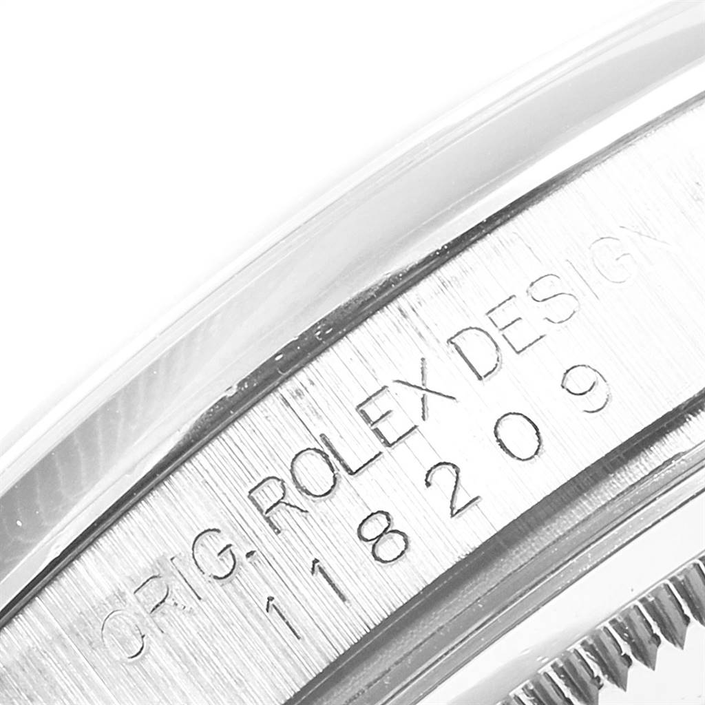This image shows the engraved serial number on the side of the Rolex President 118209 Men's White Gold Silver Dial 118209 Men's White Gold Silver Dial watch casing.