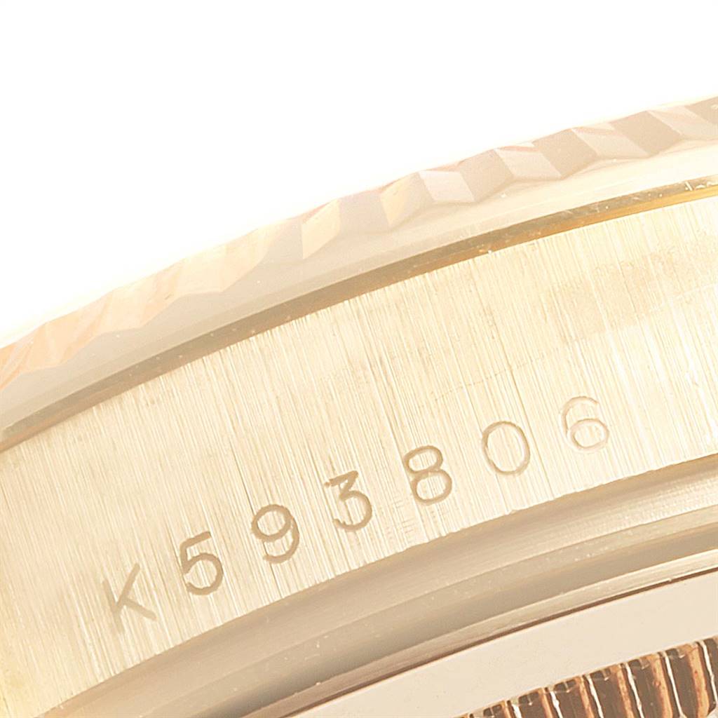 The image shows a close-up of the side of a Rolex President 118338 Men
s Yellow Gold Silver Dial 118338 Men
s Yellow Gold Silver Dial model watch, highlighting the serial number.