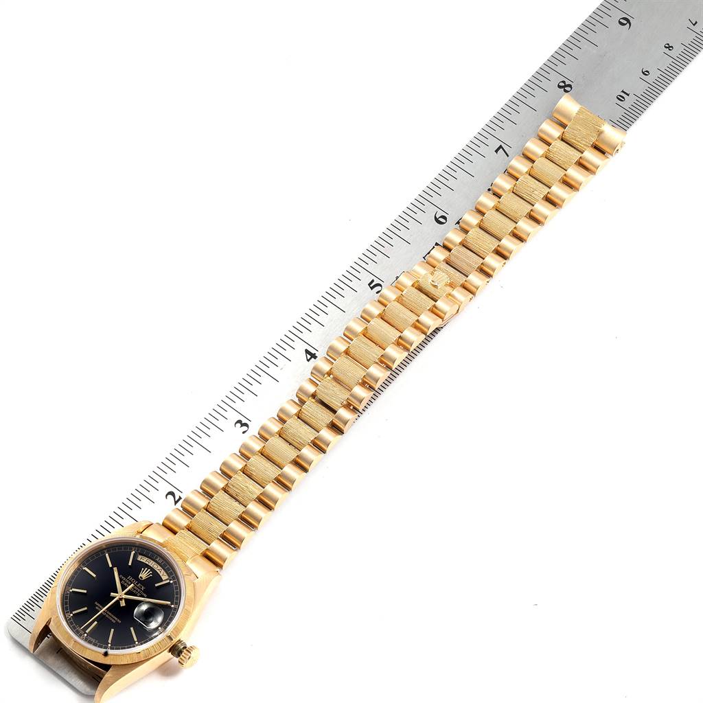 The image shows a Rolex President 18078 Men's Yellow Gold Black Dial 18078 Men's Yellow Gold Black Dial model watch laid flat beside a ruler, showcasing the watch face and entire gold bracelet.