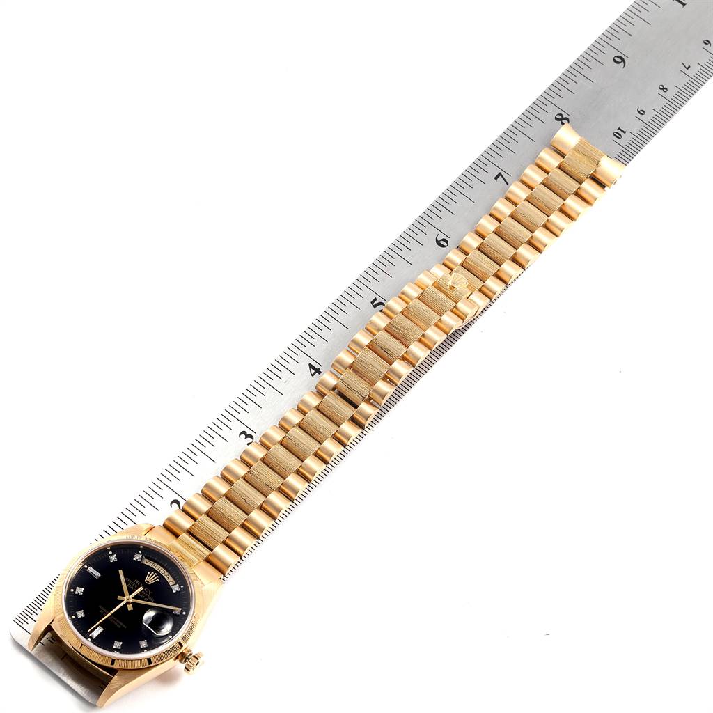 The image shows a Rolex President 18248 Men's Yellow Gold Black Dial 18248 Men's Yellow Gold Black Dial watch lying flat alongside a ruler, displaying the watch face, band, and part of the crown.