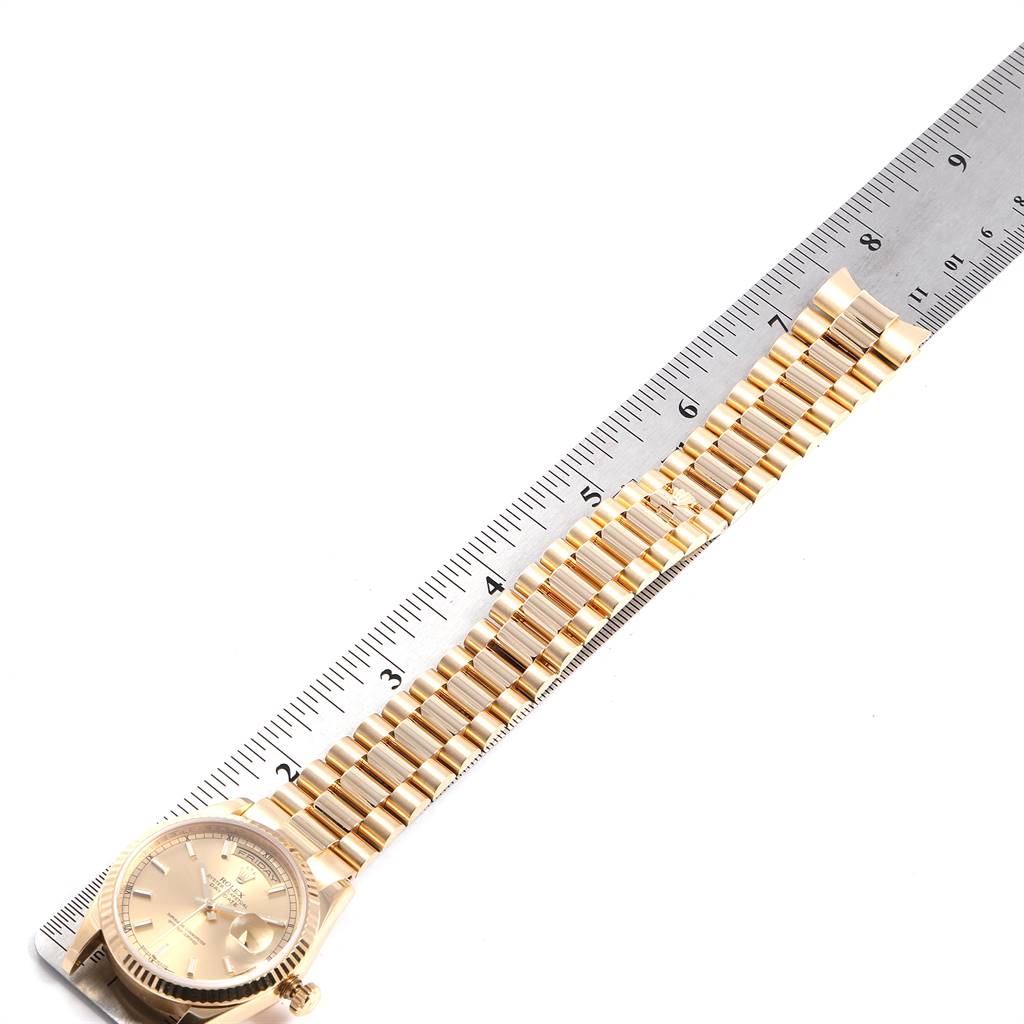 This image shows a top view of a Rolex President 118238 Men
s Yellow Gold Champagne Dial 118238 Men
s Yellow Gold Champagne Dial model watch with a ruler measuring its gold bracelet.