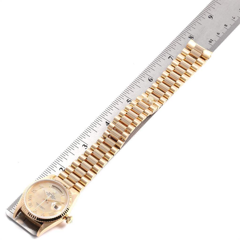 The image shows a Rolex President 18238 Men
s Yellow Gold Mother of Pearl Dial 18238 Men
s Yellow Gold Mother of Pearl Dial model watch with its bracelet aligned with a ruler, viewed from an overhead angle.
