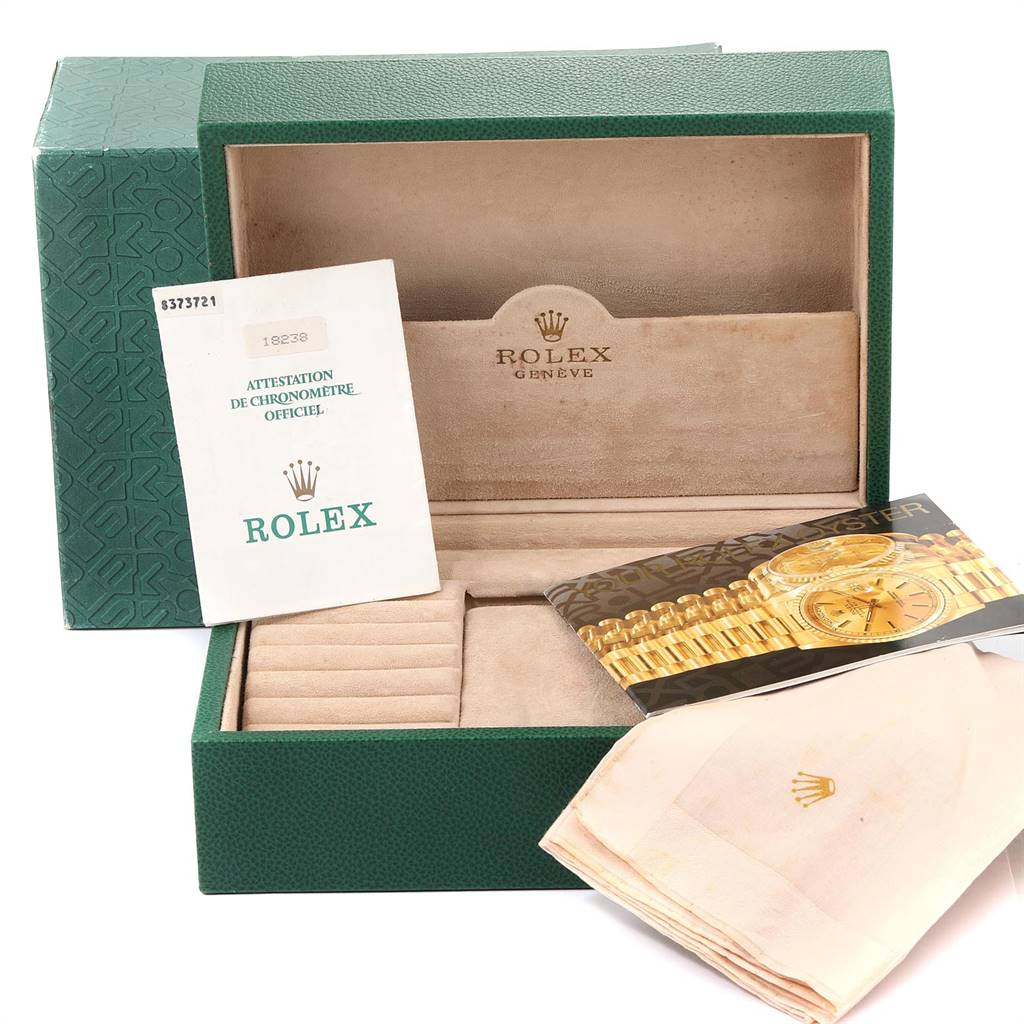 The image shows a Rolex President 18238 Men
s Yellow Gold Champagne Dial 18238 Men
s Yellow Gold Champagne Dial watch box and its accessories, including manuals, a certificate, and a cloth, from a front angle.
