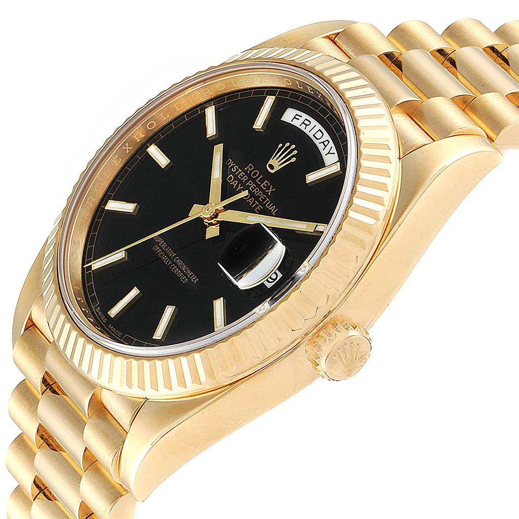 This image shows a side angle of a Rolex President 228238 Men
s Yellow Gold Black Dial 228238 Men
s Yellow Gold Black Dial model, featuring its crown, bezel, and a portion of the bracelet.