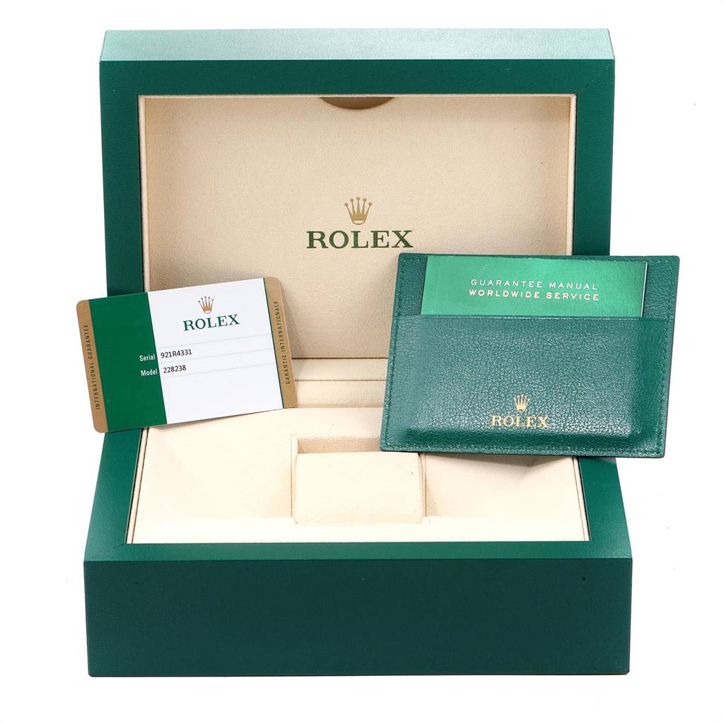 This image shows the packaging, warranty card, and guarantee manual for the Rolex President 228238 Men
s Yellow Gold Black Dial 228238 Men
s Yellow Gold Black Dial model watch.