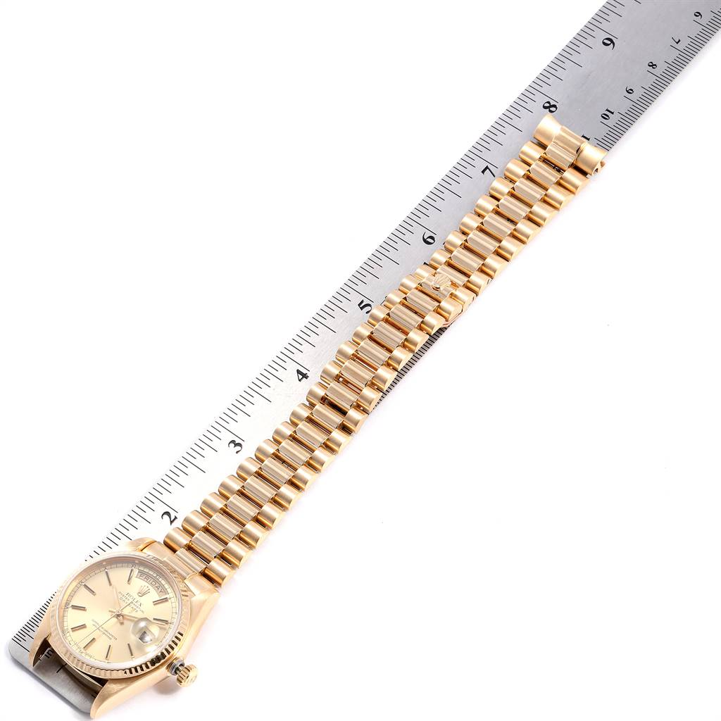 The Rolex President 18038 Men's Yellow Gold Champagne Dial 18038 Men's Yellow Gold Champagne Dial watch is shown from a top view, displaying its dial, case, bracelet, and a ruler for scale.