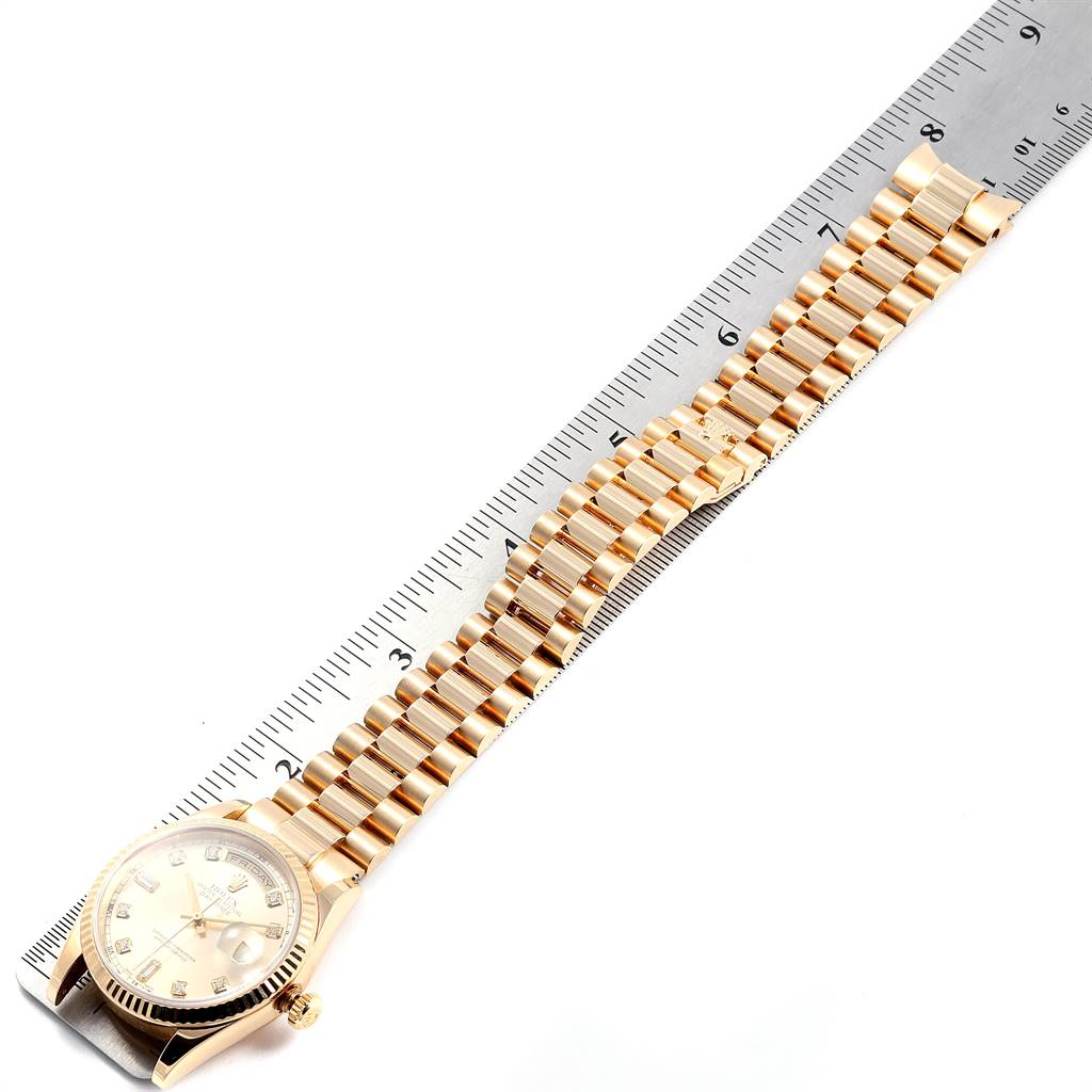 The image shows a Rolex President 118238 Men
s Yellow Gold Champagne Dial 118238 Men
s Yellow Gold Champagne Dial model watch laid flat next to a ruler, displaying its face, bezel, crown, and full bracelet.