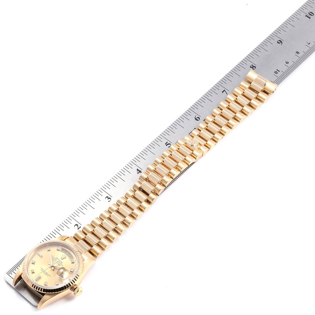 The Rolex President 18238 Men
s Yellow Gold Champagne Dial 18238 Men
s Yellow Gold Champagne Dial watch is shown flat with its bracelet extended next to a ruler for scale.