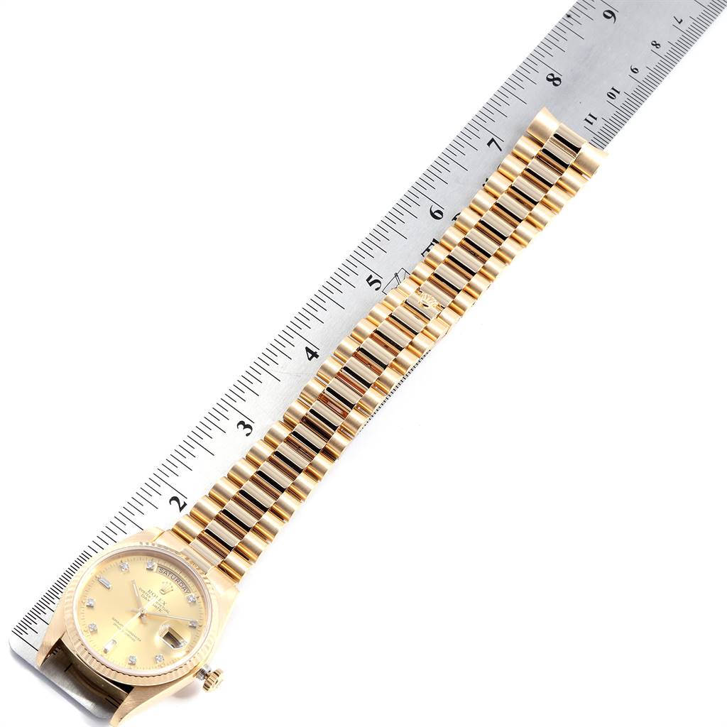 The Rolex President 18038 Men's Yellow Gold Champagne Dial 18038 Men's Yellow Gold Champagne Dial model watch is shown from a top-down angle, displaying the gold case, dial, and bracelet next to a ruler.