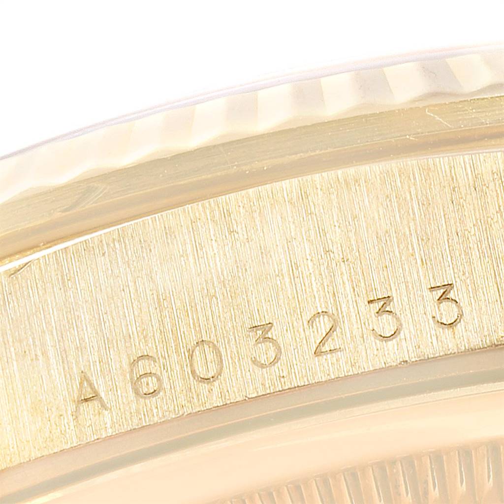 The image shows a close-up angle of the engraved serial number and part of the bezel on a President model Rolex watch.