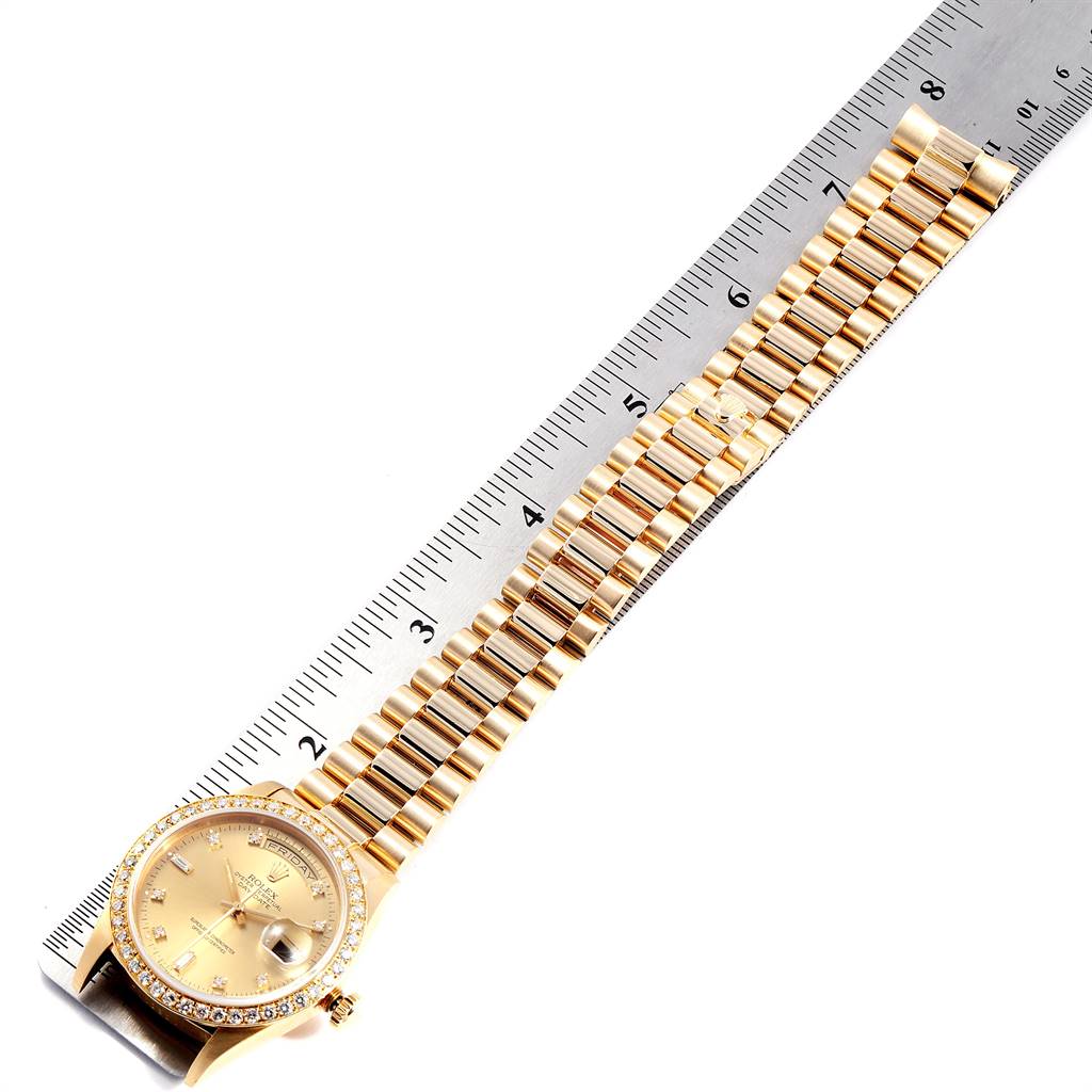 The image shows a Rolex President 18348 Men
s Yellow Gold Champagne Dial 18348 Men
s Yellow Gold Champagne Dial model watch laid flat next to a measuring ruler, displaying its dial, bezel, and entire bracelet.