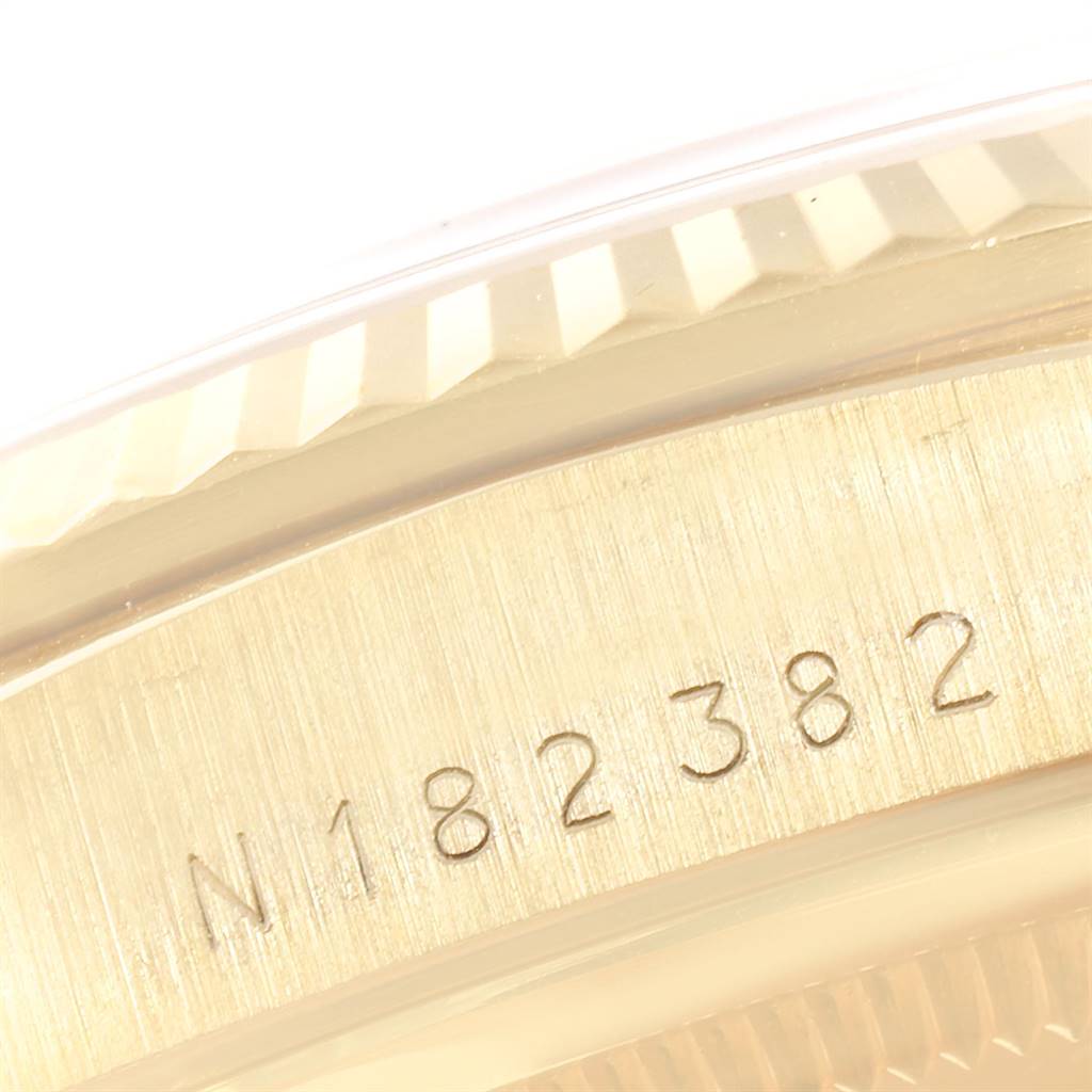 This close-up image shows part of the bezel and case of a Rolex President 18238 Men's Yellow Gold Champagne Dial 18238 Men's Yellow Gold Champagne Dial model, including a serial number.